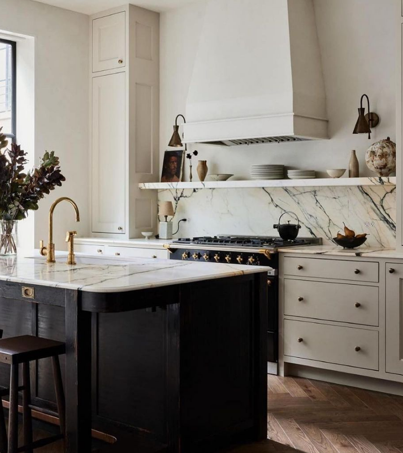 White kitchen with Marble countertops, and a 16" backsplash with a stone shelf with decorative objects about range.