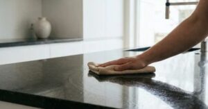 applying sealer to granite countertop surface for protection  